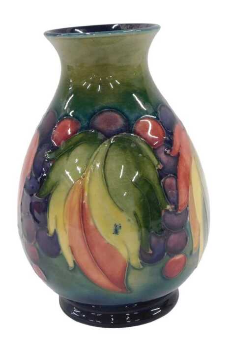A Moorcroft pottery Leaf and Berry pattern vase, of shouldered form on circular foot, on green...
