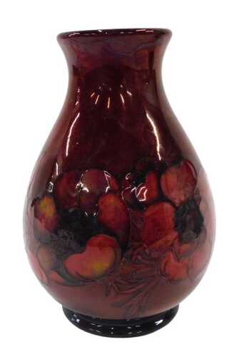 A Moorcroft pottery flambe Anemone pattern vase, of shouldered form on circular foot, on red...