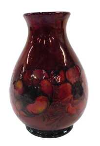 A Moorcroft pottery flambe Anemone pattern vase, of shouldered form on circular foot, on red...