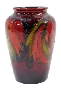 A Moorcroft pottery flambe Leaf and Berry pattern vase, of shouldered form, on red ground, 16cm...