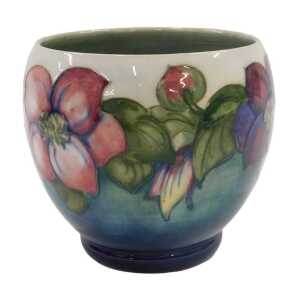 A Moorcroft pottery Clematis pattern vase, of compressed circular form on circular foot, on...