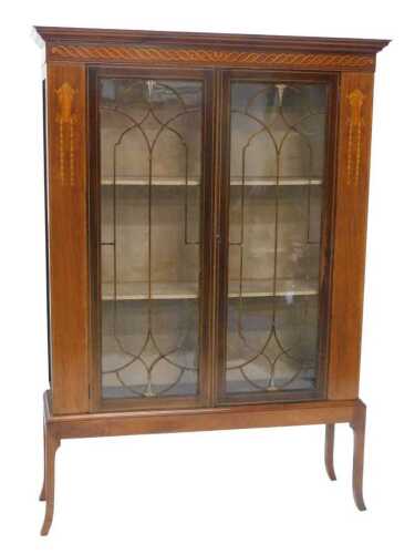 An Edwardian mahogany and boxwood strung Sheraton revival display cabinet, with a stencilled...