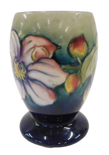 A Moorcroft pottery Clematis pattern goblet vase, on green and blue ground, 15cm high.