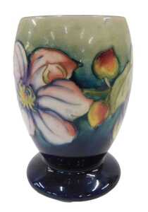 A Moorcroft pottery Clematis pattern goblet vase, on green and blue ground, 15cm high.