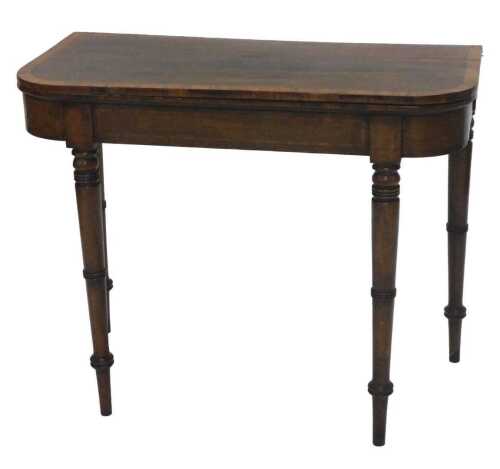 An early 19thC walnut D end fold over card table, the wide crossbanded top hinging to reveal a...