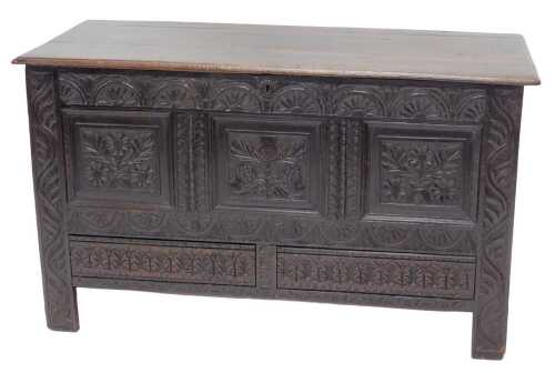 An early 18thC oak three panelled coffer, the plain lid revealing a plain interior, with heavily...