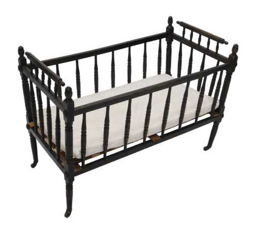 An early 20thC beech framed crib, of rectangular form, with turned supports on castors, with...
