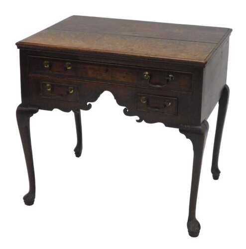 An 18thC oak lowboy, the rectangular moulded top raised above one long and two short frieze...