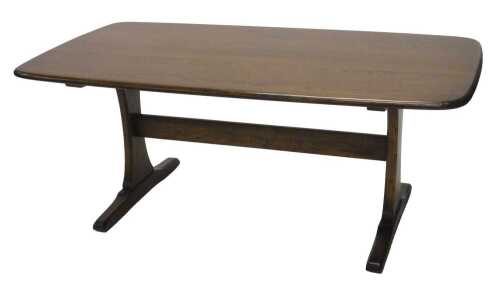 A late 20thC Ercol coffee table, the oblong top, on inverted legs joined by a plain horizontal...