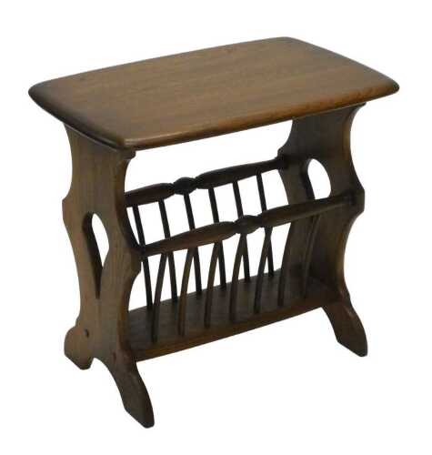 A late 20thC Ercol newspaper rack, the oblong top raised on inverted stiles, with pierced sides,...