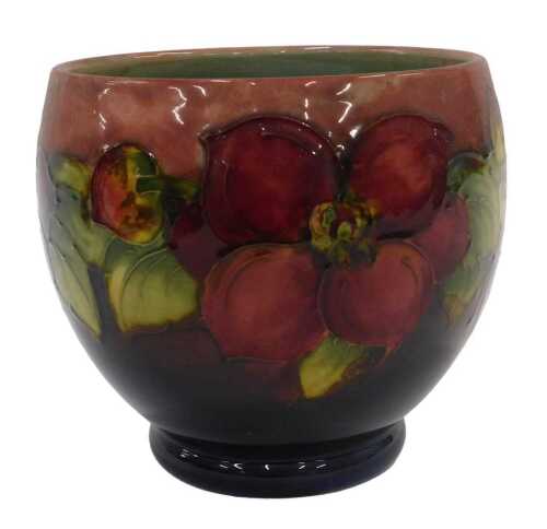 A Moorcroft pottery flambe Clematis pattern vase, of tapering circular form on circular foot,...