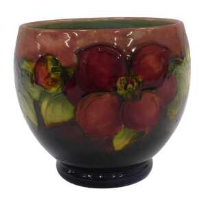 A Moorcroft pottery flambe Clematis pattern vase, of tapering circular form on circular foot,...