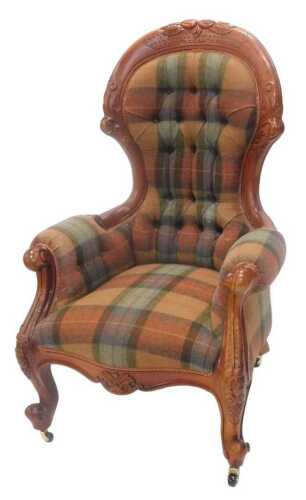 A Victorian style mahogany finished spoonback armchair, with button back and arms, in tartan...