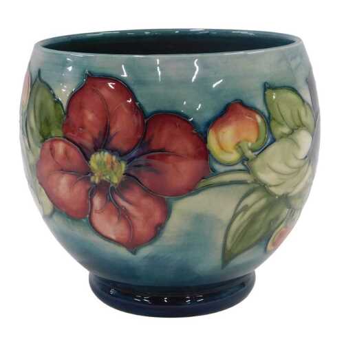A Moorcroft pottery Clematis pattern bowl, of tapering circular form on circular foot, on green...