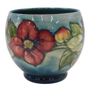 A Moorcroft pottery Clematis pattern bowl, of tapering circular form on circular foot, on green...