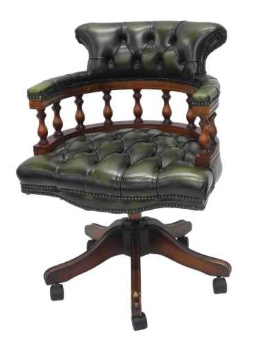 A green leather captain's office chair, with shaped back and C shaped arms, with serpentine seat...
