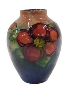 A Moorcroft pottery flambe Clematis pattern vase, of shouldered circular form, on red ground,...