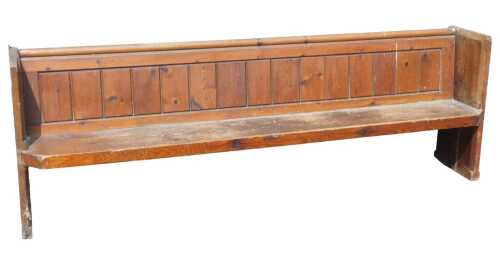 A 19thC pine pew, with book rest and panelled back, shaped sides, and a canted seat, 82cm high,...