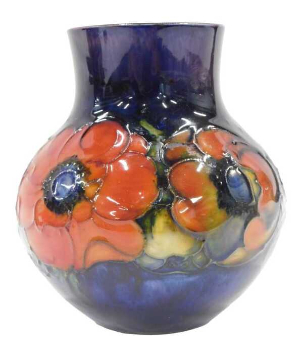 A Moorcroft pottery Anemone pattern squat vase, with compressed stem, bellied body, on blue...