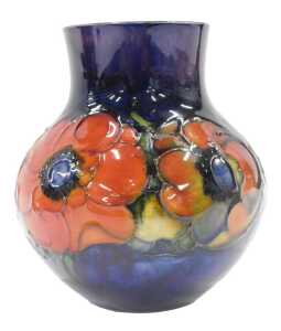 A Moorcroft pottery Anemone pattern squat vase, with compressed stem, bellied body, on blue...
