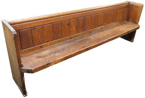 A 19thC pine pew, with book rest and panelled back, shaped sides, and a canted seat, 82cm high,...