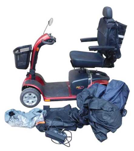 A Pride Colt Deluxe four wheeled mobility scooter, in red trim, with front basket and cover,...