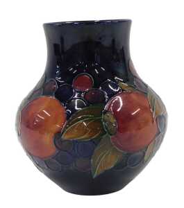 A Moorcroft pottery Pomegranate pattern vase, of compressed bellied circular form, on blue...