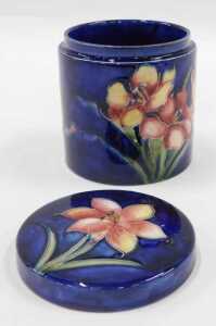 A Moorcroft pottery Freesia pattern jar and cover, of circular form, on blue ground, 11cm high. - 2