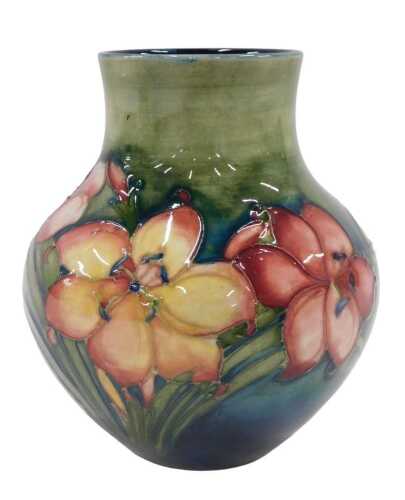 A Moorcroft pottery Freesia pattern vase, of bellied circular form, on green ground, 14cm high.