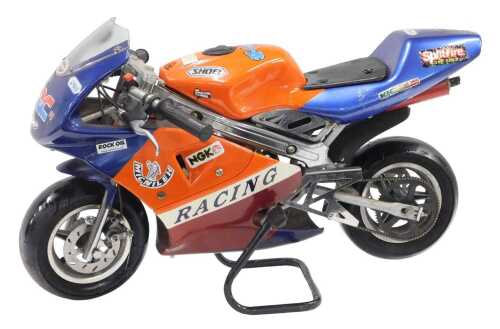 A child's HRC Shoei labelled mini motorised motorbike, with petrol engine, in orange and blue...