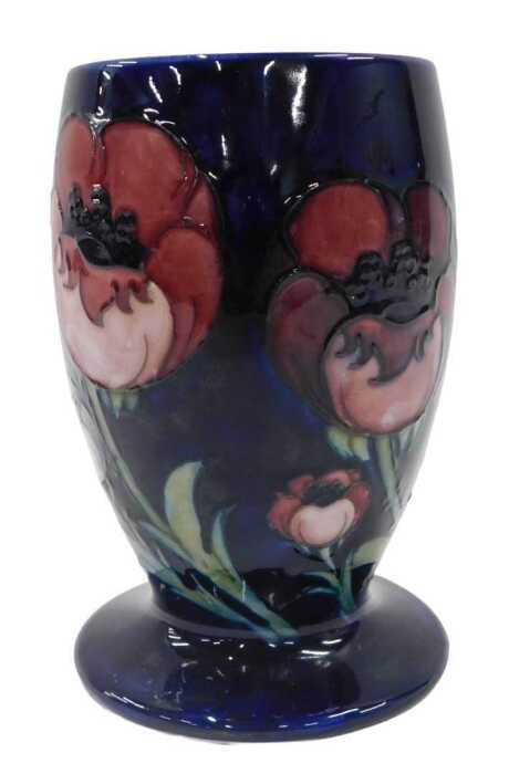 A Moorcroft pottery Big Poppy pattern vase, of circular form on circular foot, on blue ground,...