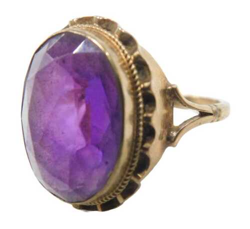A 9ct gold amethyst dress ring, the oval faceted amethyst in a rub over, rope twist and fluted...
