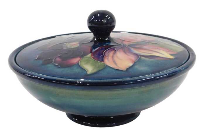 A Moorcroft pottery Clematis pattern jar and cover, of compressed circular form, 16cm wide.