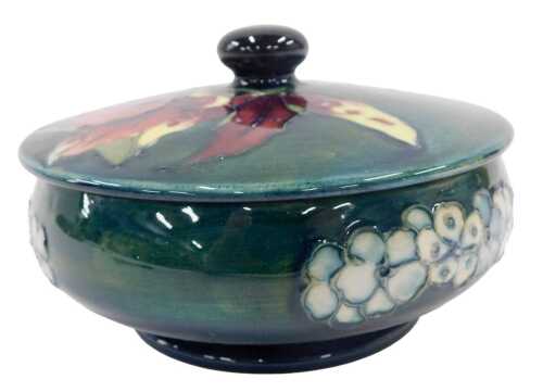 A Moorcroft pottery Frilled and Slipper Orchid pattern jar and cover, of compressed circular...