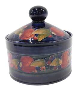 A Moorcroft pottery Pomegranate pattern jar and cover, with circular knop, on blue ground, 15cm...