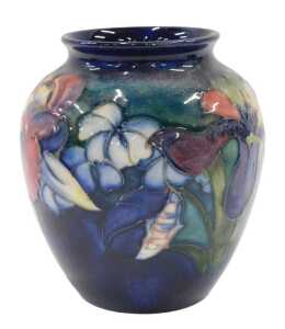 A Moorcroft pottery Orchid pattern vase, of tapering circular form, on blue and green ground,...