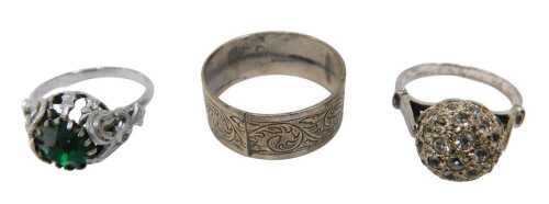 Three dress rings, comprising a raised ball and paste stone set dress ring, a patterned wedding...