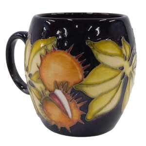 A Moorcroft pottery Anna Lily pattern mug, on dark purple ground, 10cm high.