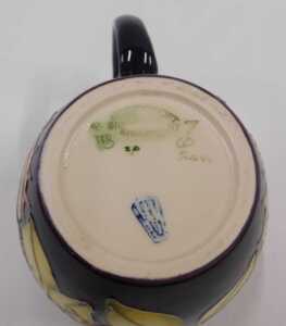 A Moorcroft pottery Anna Lily pattern mug, on dark purple ground, 10cm high. - 2