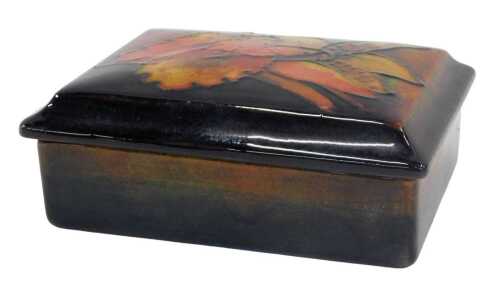 A Moorcroft pottery flambe box and cover, 6cm high.