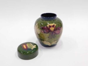 A Moorcroft pottery Columbine pattern ginger jar and cover, of tapering circular form, on green... - 2
