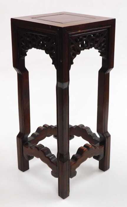 A small Chinese hardwood urn stand, of square section, with scrolling fretwork raised on square...
