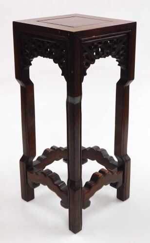 A small Chinese hardwood urn stand, of square section, with scrolling fretwork raised on square...
