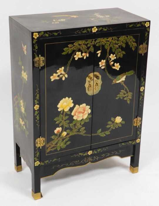 A Chinese black lacquer cabinet, of rectangular section, painted with birds, trees in blossom,...