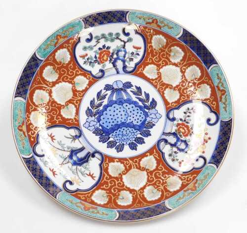 A late 20thC Japanese Imari charger, decorated with reserves of trees and prunus blossom, and...