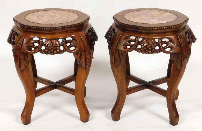A pair of Chinese hardwood urn stands, the top inset with circular red marble, over fretwork...