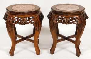 A pair of Chinese hardwood urn stands, the top inset with circular red marble, over fretwork...