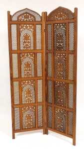 An Eastern hardwood two fold screen, with fretwork paneling and carved decoration of trees in...