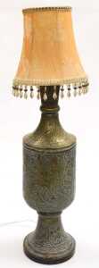 An early 20thC Anglo-Indian brass vase, converted to a table lamp, embossed with huntsman, gurus,...