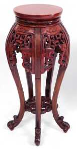 A pair of Chinese hardwood urn stands, stained red, each with a plain circular top, above... - 2